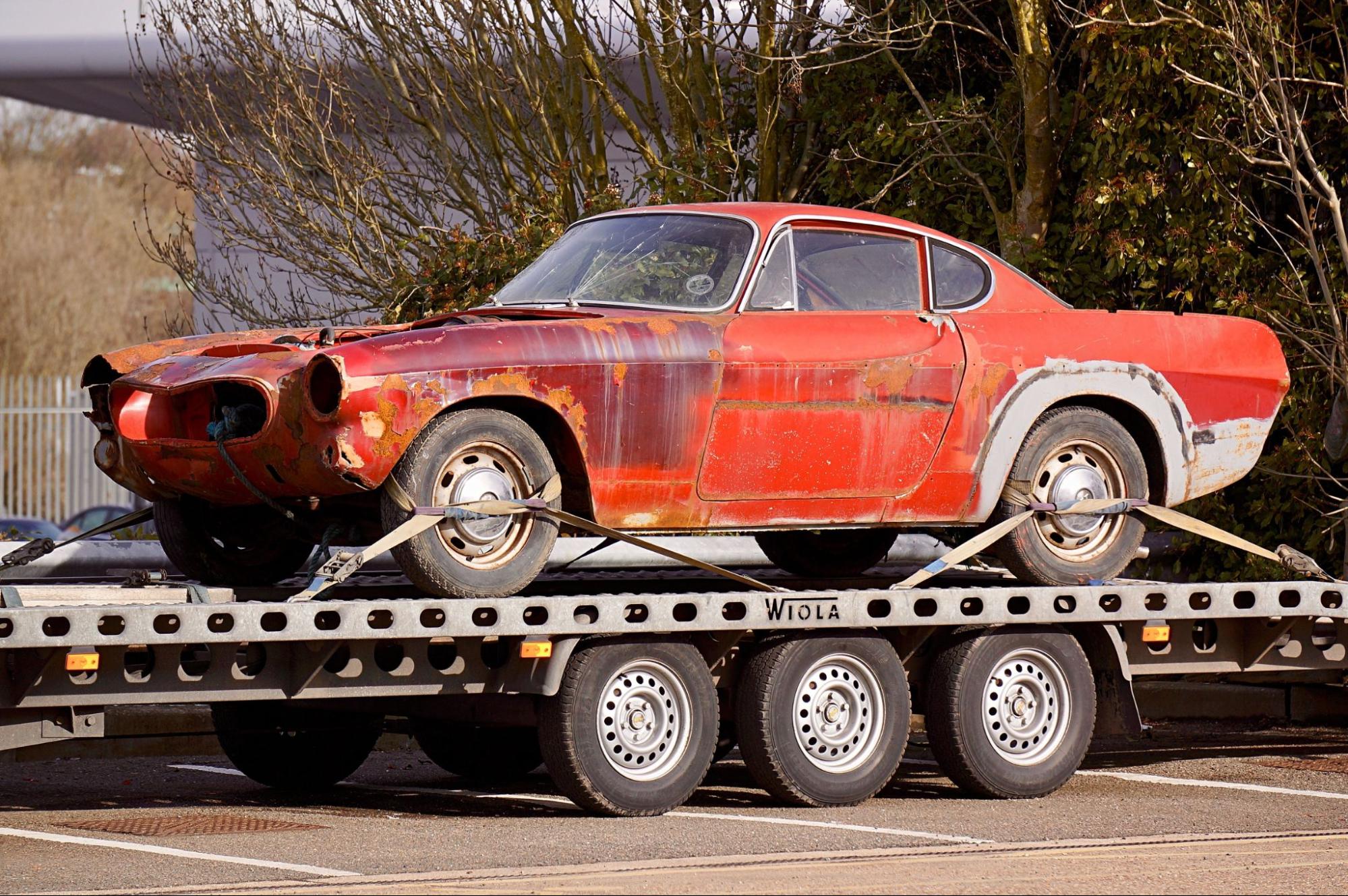 an inoperable car loaded onto the truck trailer ready to be transported.